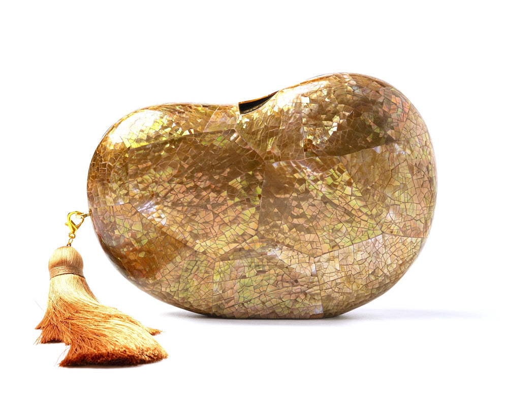 Front view of Lucia Clutch in beige showing bean-shaped iridescent shell, tonal tassel, and gold hardware on white background