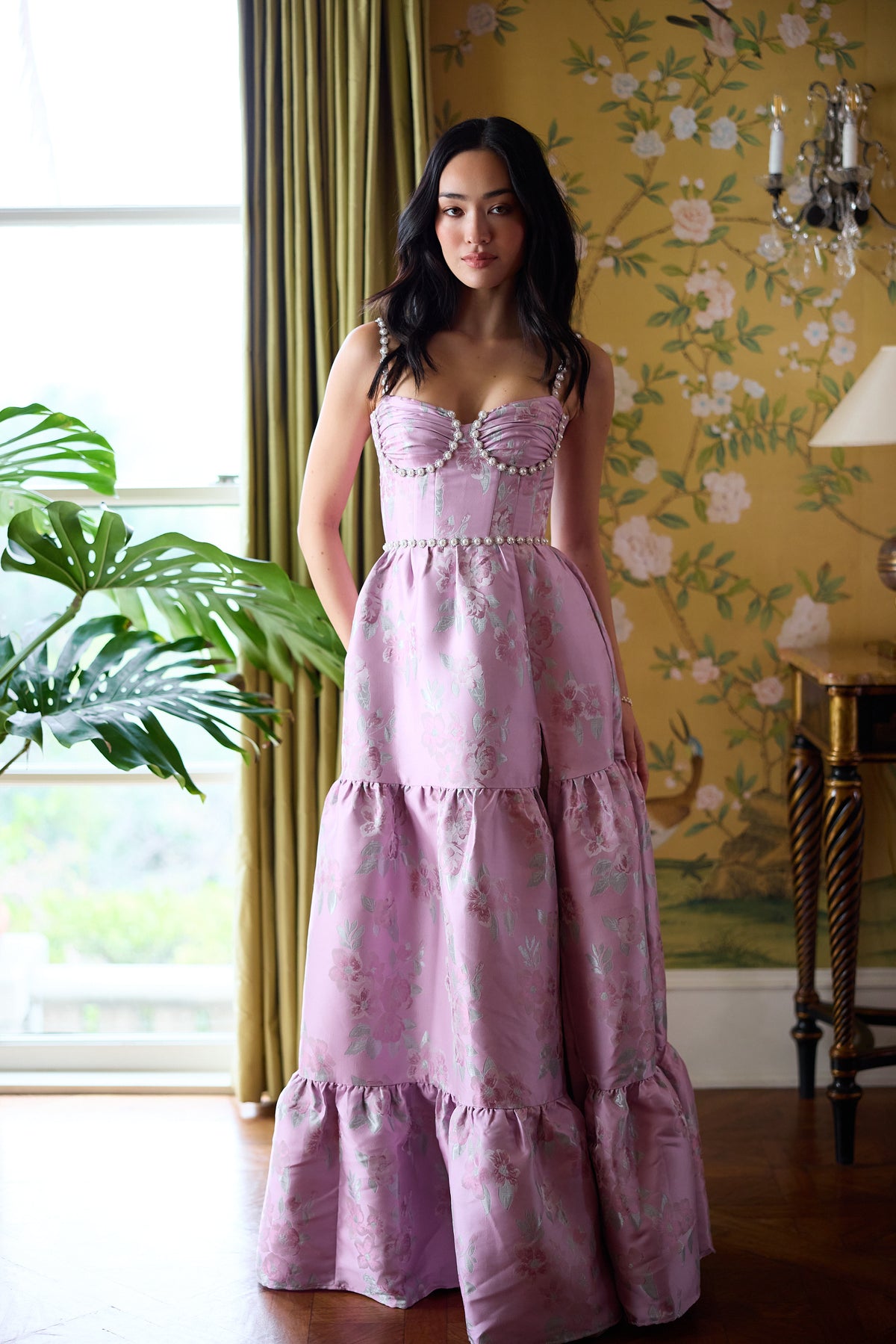 Front view of The Lucetta Dress in Orchid Baroque Floral showing a corset bodice and beaded trim in a floral room