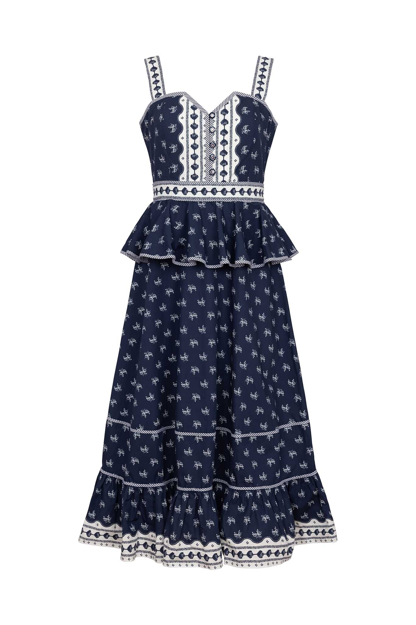 The Lacey Dress has a sweetheart neckline, a fitted bodice, peplum hem, and painted flower buttons.