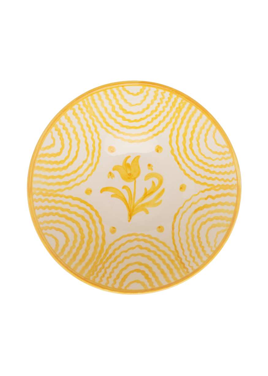 Top-down view of Flor large yellow serving bowl with hand-painted central flower and concentric wavy yellow bands
