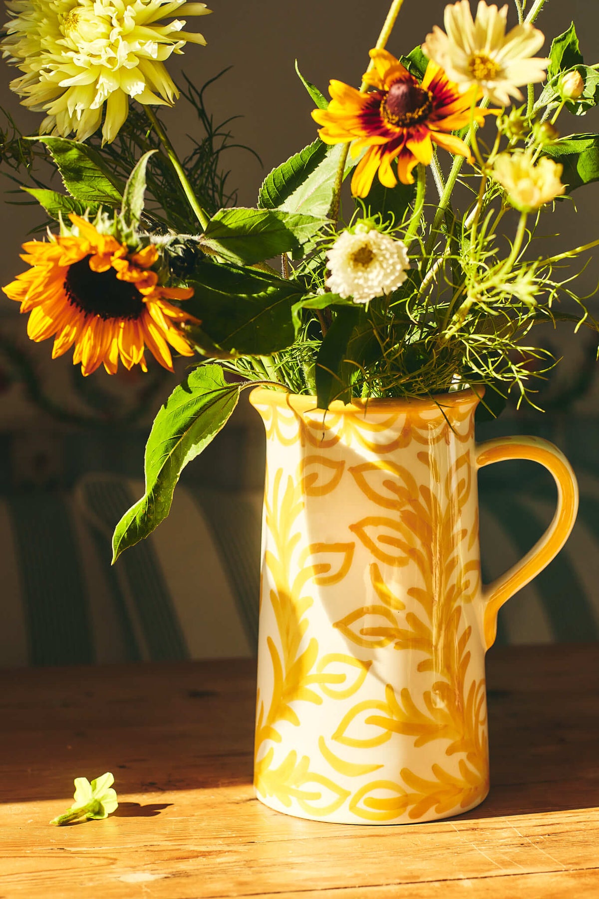 Front of Late Afternoon Large Yellow Jug showing hand-painted repintado motif and handle with sunflowers on wooden table
