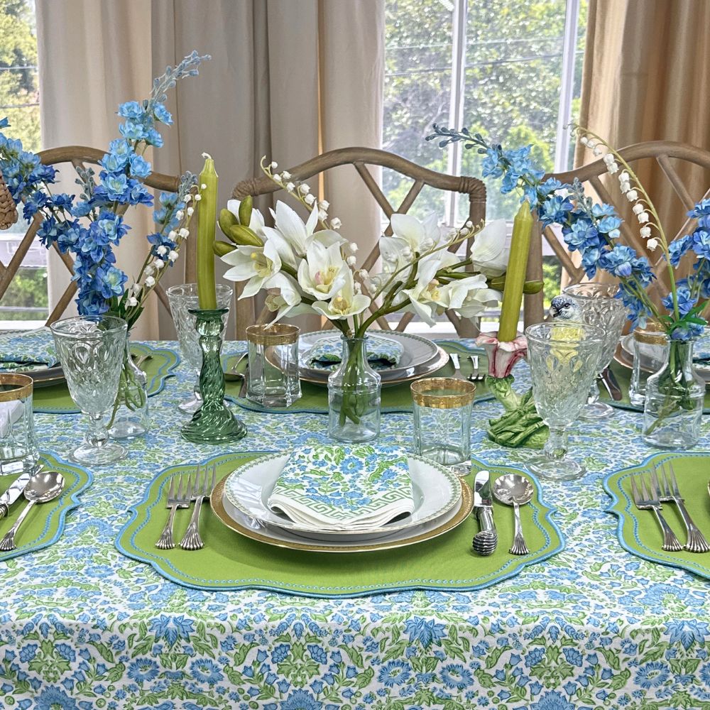 Elegant table setting with blue and green floral hand block printed tablecloth and matching napkin with greek key border and luxury embroidered placemat with decorations 