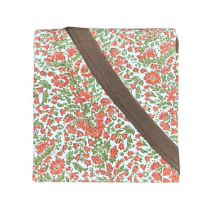 A hand block printed tablecloth, featuring a floral pumpkin and  sage green floral pattern on a white background, finished with a brown band and Greek key border at the bottom, 90 inch round tablecloth, Thanksgiving tablecloth