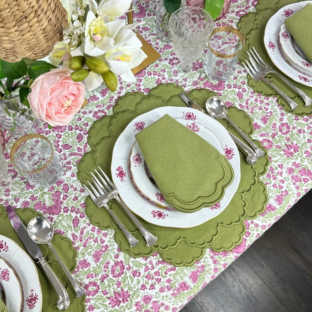 Elegant table setting with floral hand block printed tablecloth, green sage luxury embroidered placemats, and napkins and silverware.