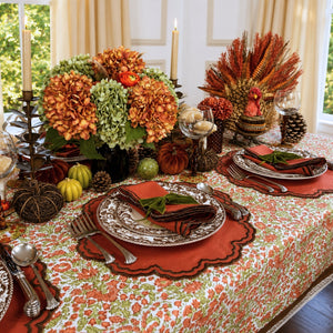 A hand block printed tablecloth, featuring a floral pumpkin and sage green floral pattern on a white background, finished with a brown band and Greek key border at the bottom, Thanksgiving tablecloth, luxury table linens
