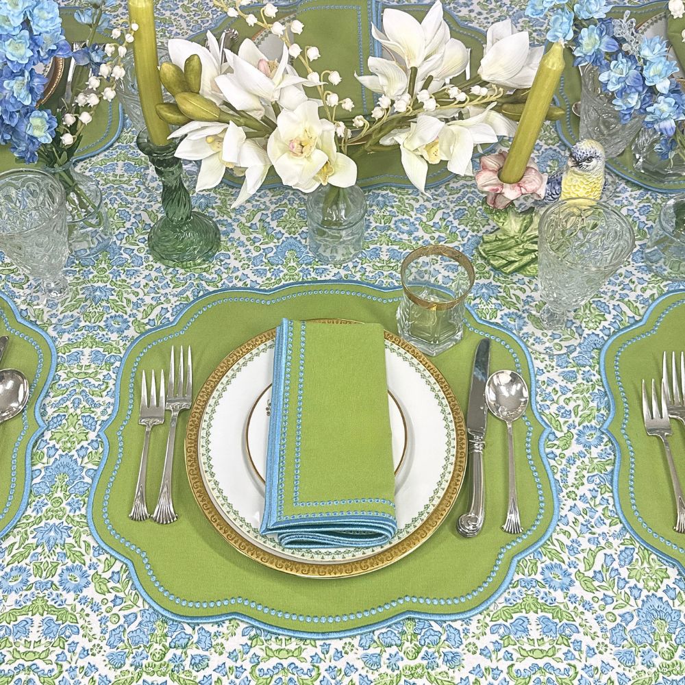 Elegant table setting with blue and green floral hand block printed tablecloth  and luxury embroidered placemat  and napkin  in green and blue with decorations 