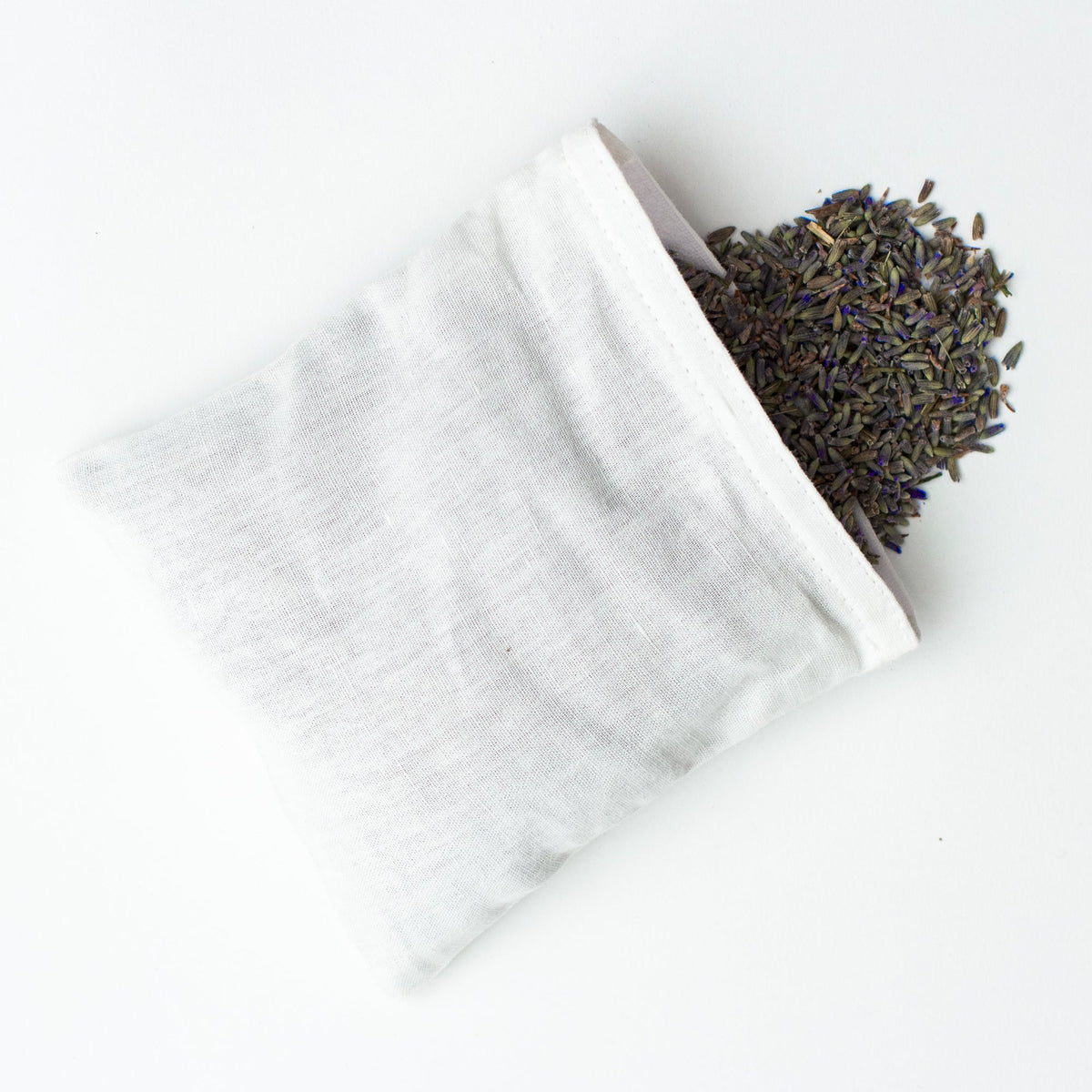 Top-down view of Daisies Scatter linen sachet filled with French lavender on white background
