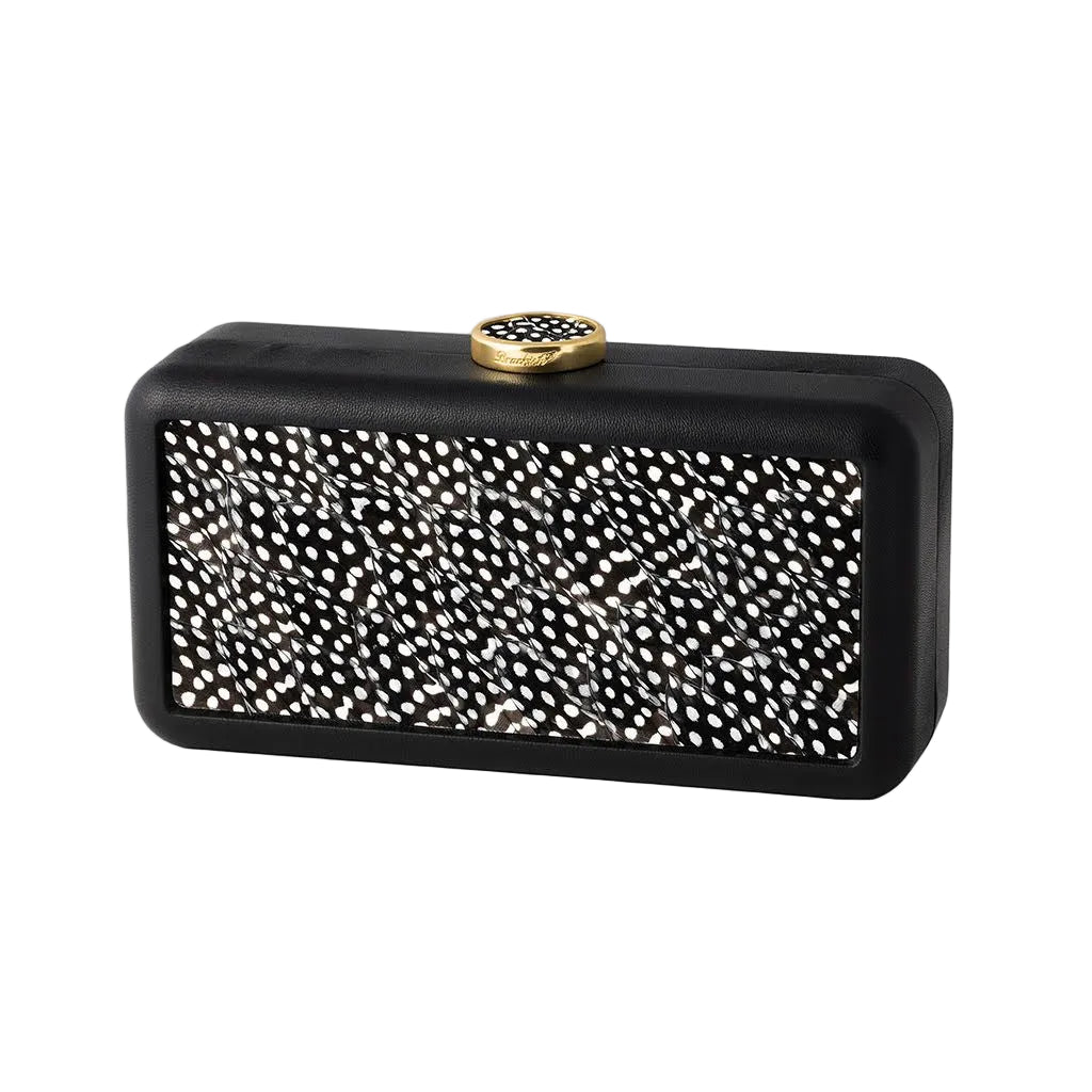 Front view of Le Marais clutch in Guinea showcasing black-and-white guinea feather panel and gold clasp on white background