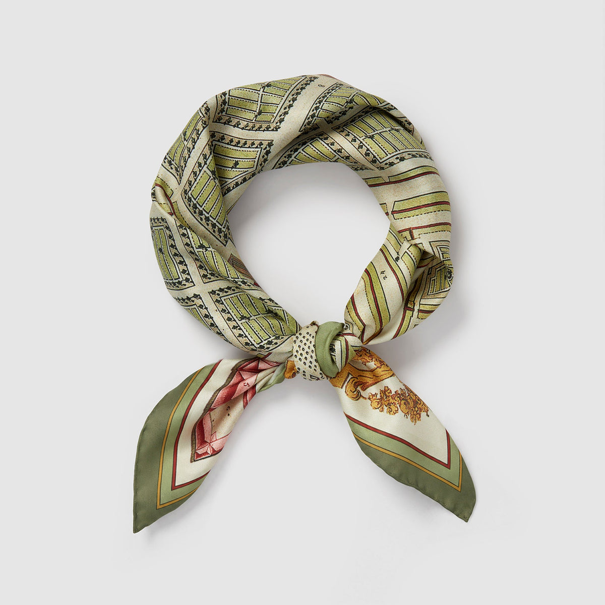 A product photograph of a square silk scarf styled into a knotted loop, showcasing its sage green borders and an illustrated map pattern. The silk fabric is draped to form a circle with the two pointed ends neatly tied together at the bottom, presented against a clean, light gray background.