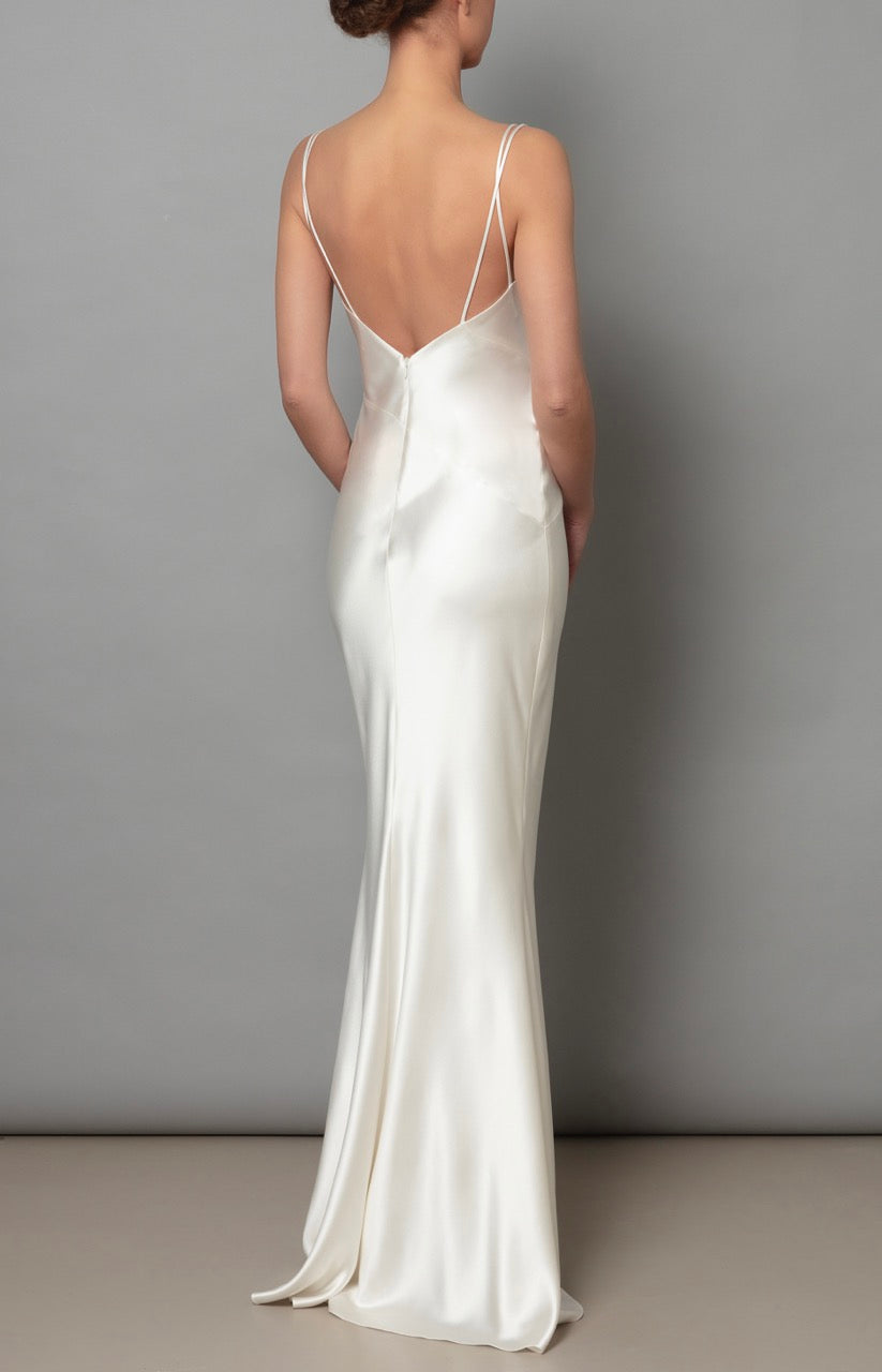 Back view of Lilou Dress in Ivory showcasing satin spaghetti straps and bias cut with gray studio background