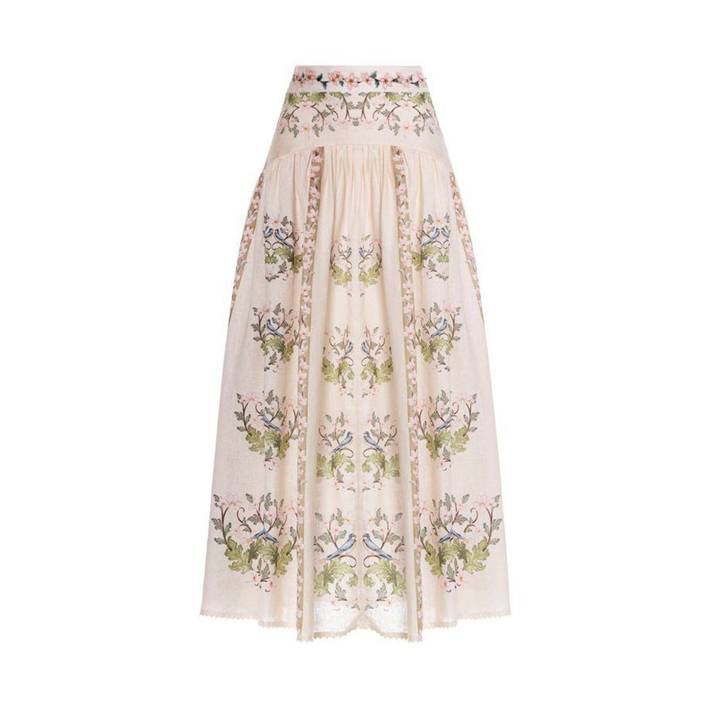 Front view of Curua Anhelo linen maxi skirt with hand-embroidered floral panels, high waistband and high-low hem on white