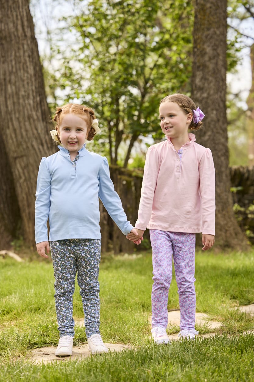 Little English traditional children's clothing.  Long sleeve Hastings polo in light pink with ruffle collar and purple floral detailing. Paired with Purple floral leggings for little girls.  Light blue Hastings polo with green floral detail paired with green floral leggings.