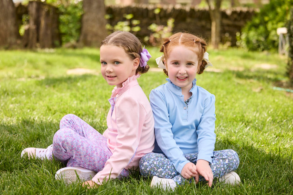 Little English traditional children's clothing.  Long sleeve Hastings polo in light pink with ruffle collar and purple floral detailing. Paired with Purple floral leggings for little girls.  Light blue Hastings polo with green floral detail paired with green floral leggings.