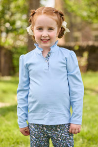 Little English traditional children's clothing.  Long sleeve Hastings polo in light blue with ruffle collar and green floral detailing. Paired with green floral leggings for little girls.  