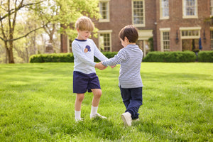 Little English traditional children's clothing.  Light blue and navy Winslow Stripe long sleeve polo shirt paired with navy essential jogger.  Light blue stripe long sleeve applique t-shirt with football and helmet applique paired with navy twill basic shorts.