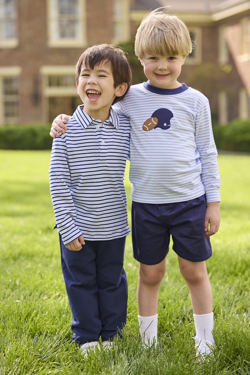 Little English traditional children's clothing.  Light blue and navy Winslow Stripe long sleeve polo shirt paired with navy essential jogger.  Light blue stripe long sleeve applique t-shirt with football and helmet applique paired with navy twill basic shorts.
