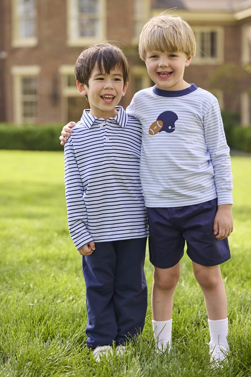 Little English traditional children's clothing.  Light blue and navy Winslow Stripe long sleeve polo shirt paired with navy essential jogger.  Light blue stripe long sleeve applique t-shirt with football and helmet applique paired with navy twill basic shorts.