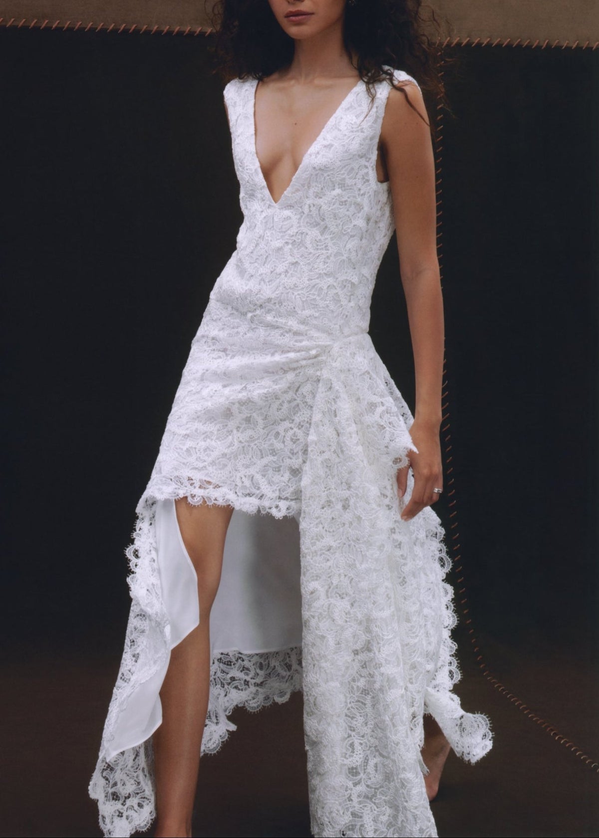 Front view of Evie Lace Dress showcasing white asymmetrical Italian lace and deep V front with dark background