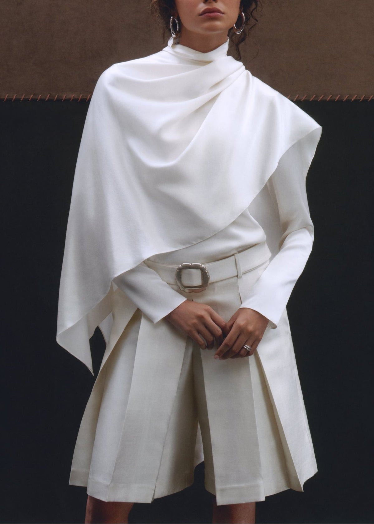 Front view of white Kimi Shorts showcasing box pleats, flared fit, and detachable belt on a model
