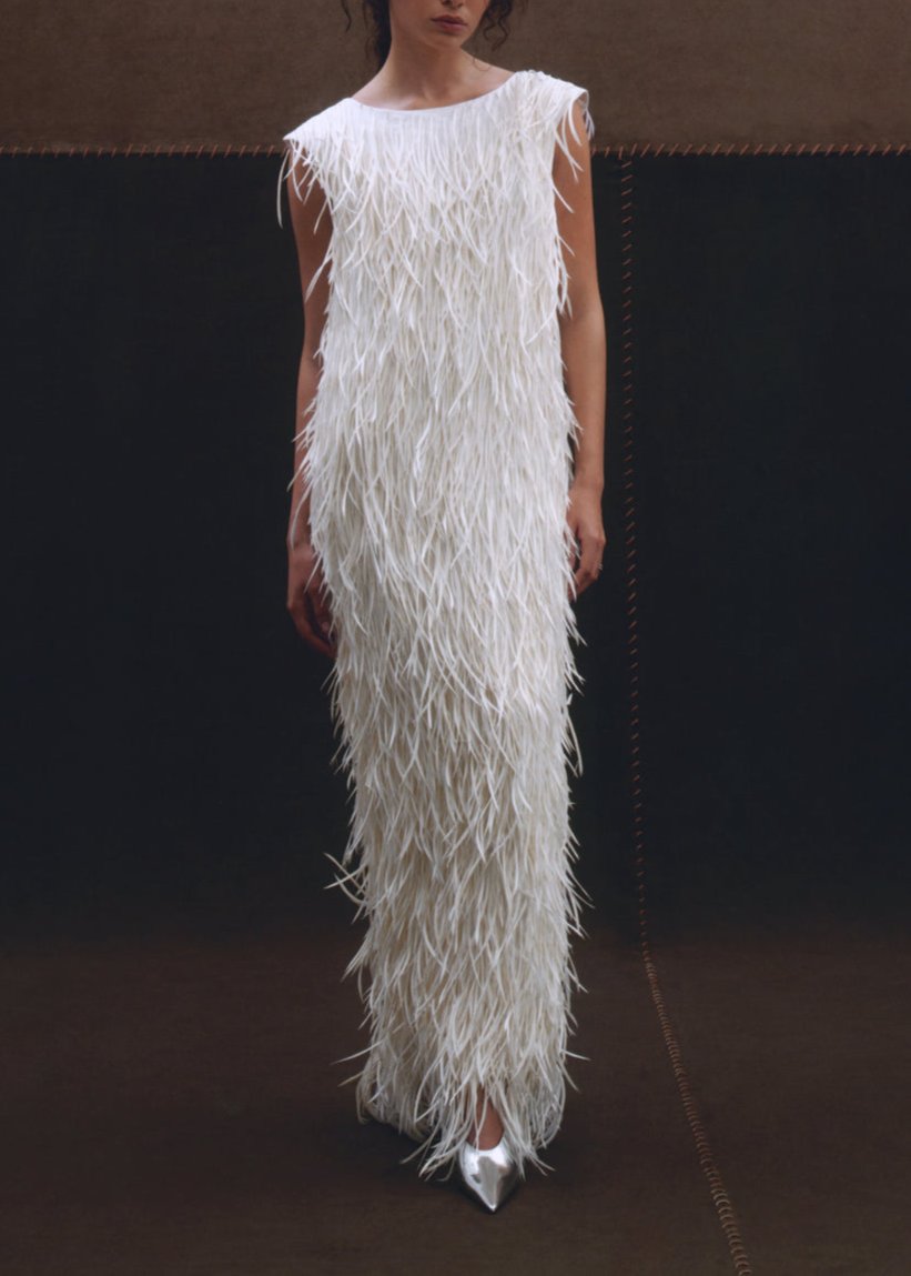 Front view of the white Dorothy Gown on a model, showcasing hand-embroidered goose feathers against a dark studio background