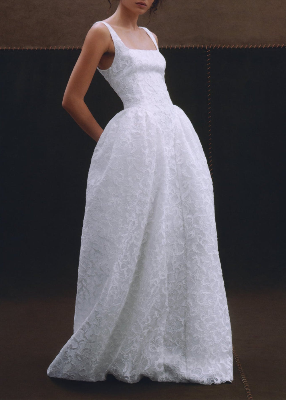 Three-quarter view of the Agnes Gown showcasing Italian lace, square neckline, and full skirt against a dark background