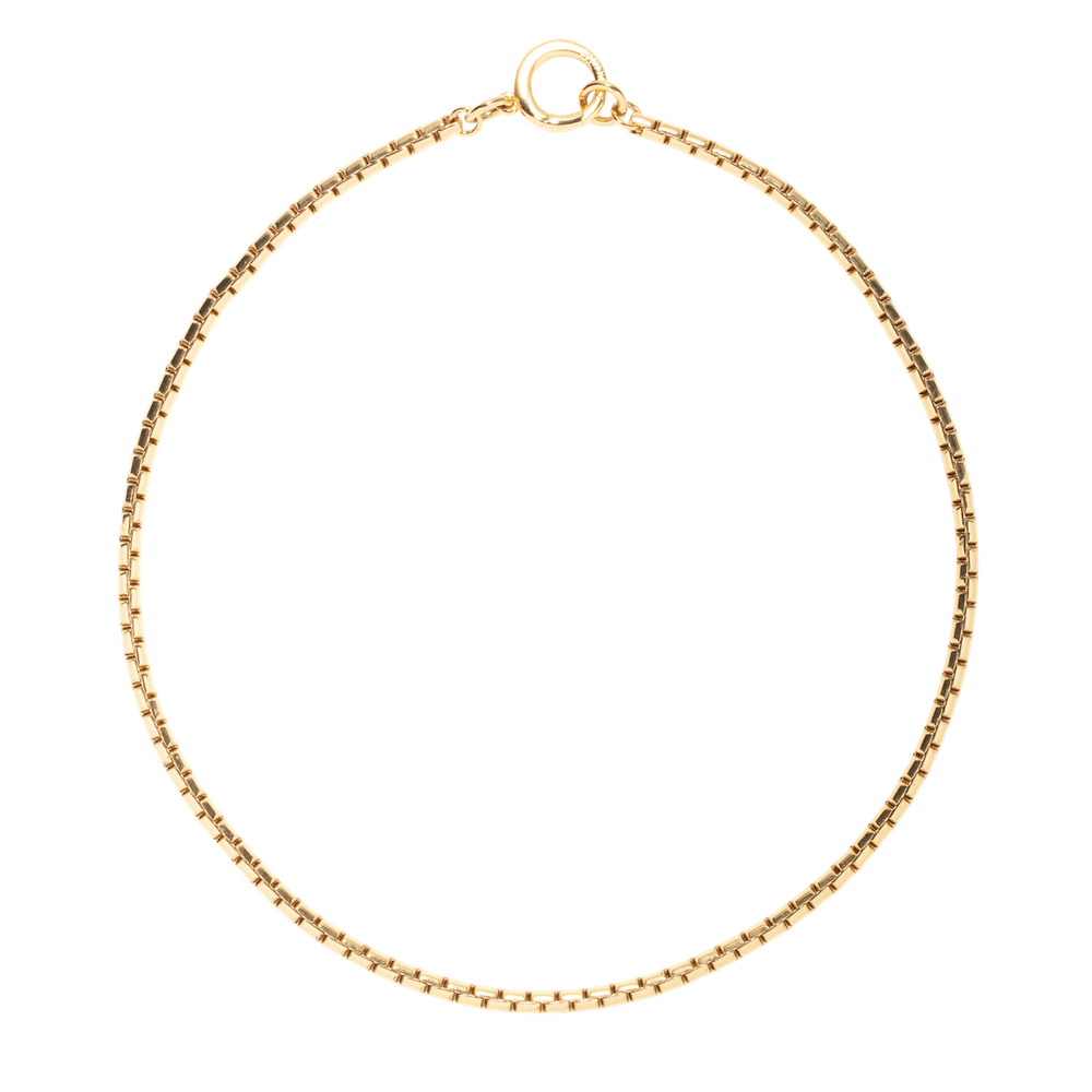 Flat lay of Scottie Chain Necklace showcasing gold box chain and oversized clasp on white background