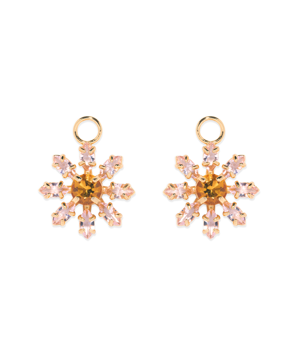 Front view of pair of Maisie Flower huggie charms showing pink glass petal stones and gold finish on black background
