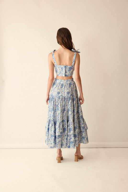 Back view of Mia Top in Blue showcasing adjustable bow straps and cropped waist with a neutral studio background