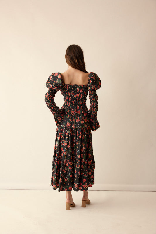 Back view of Gracie Top in Midnight Garden showing smocked bodice, puff long sleeves, and square back on a beige studio background