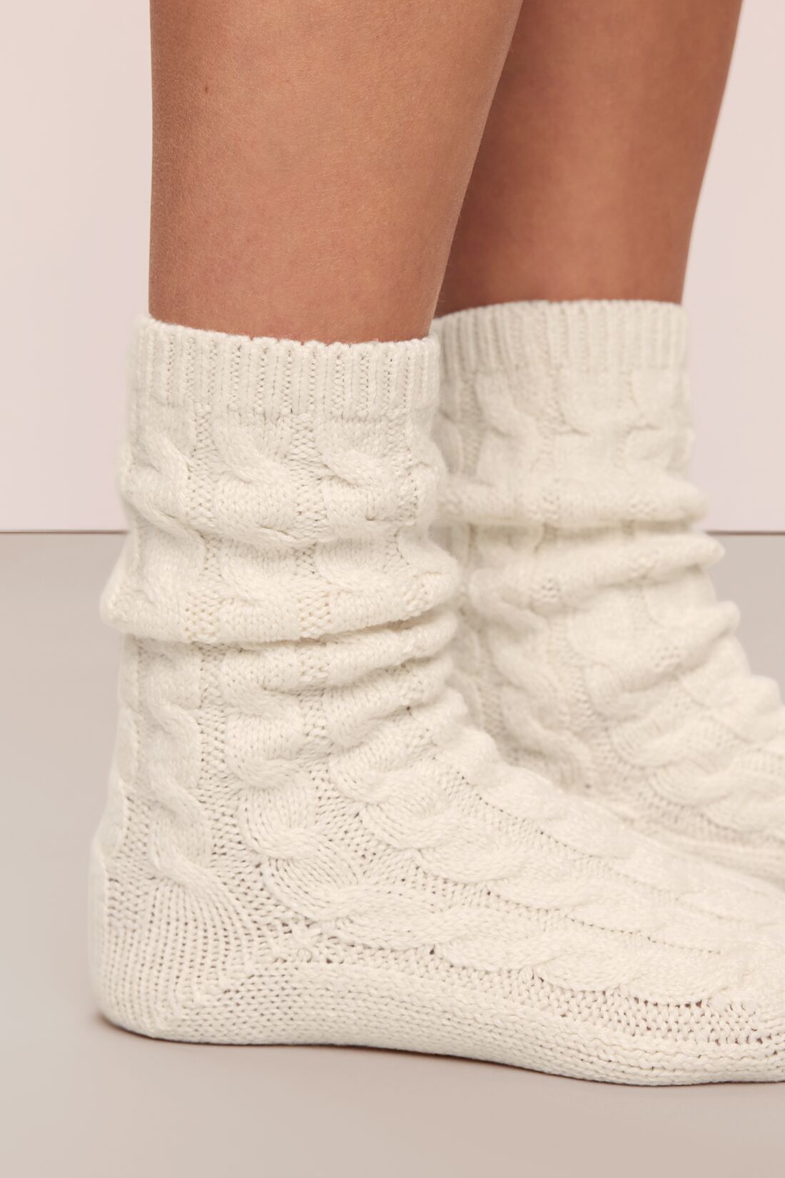 Close-up of Cozy Sock in ivory showcasing its scrunched crew-length knit with legs against a neutral background