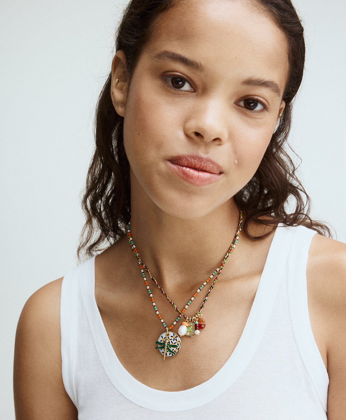 Close up of The Happy Place Necklace on model showing multicolor seed beads, mother of pearl pendant and dragonfly charm