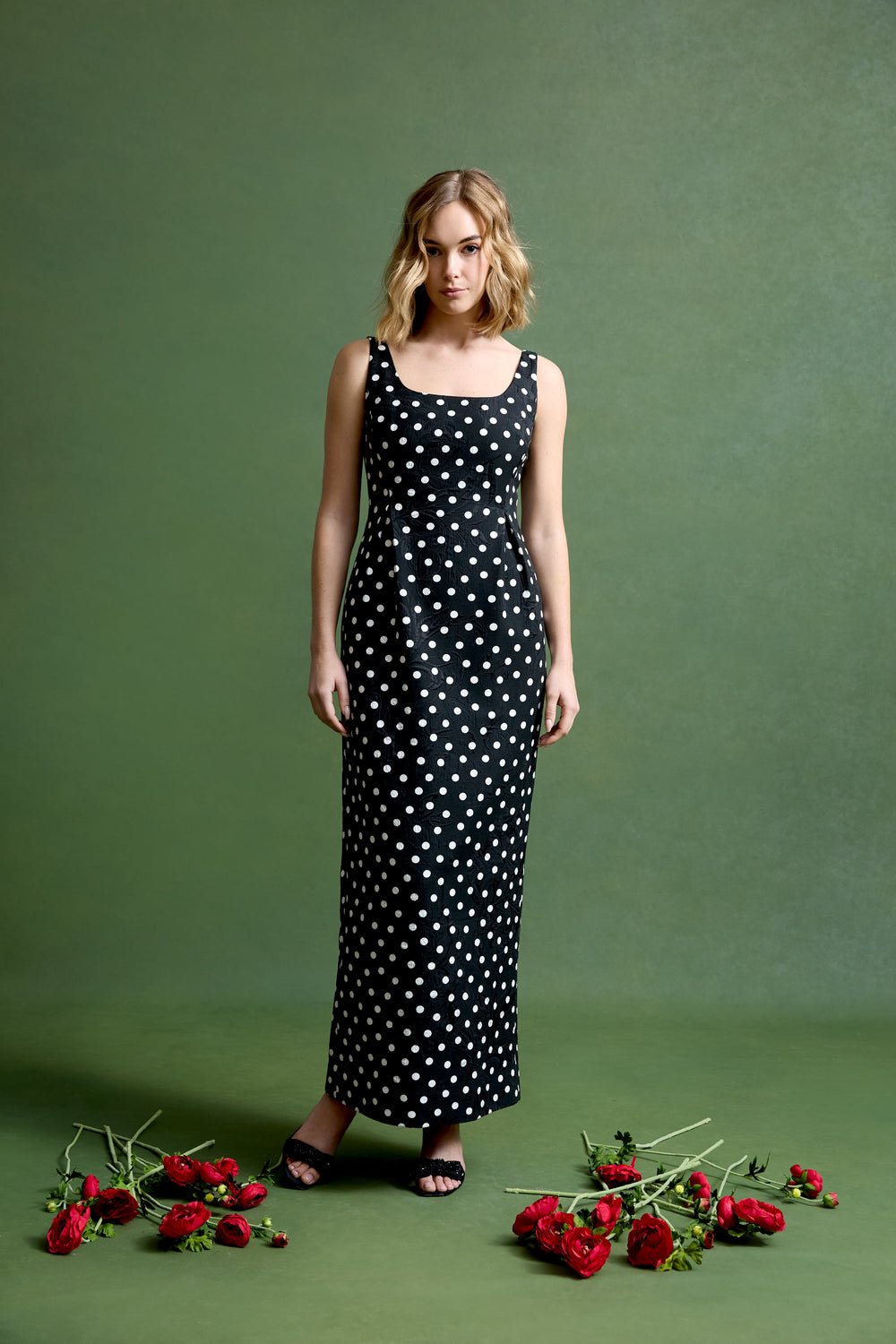 Front view of Kendall gown showcasing square neckline, fitted waist, and black dancing dot brocade with green studio background