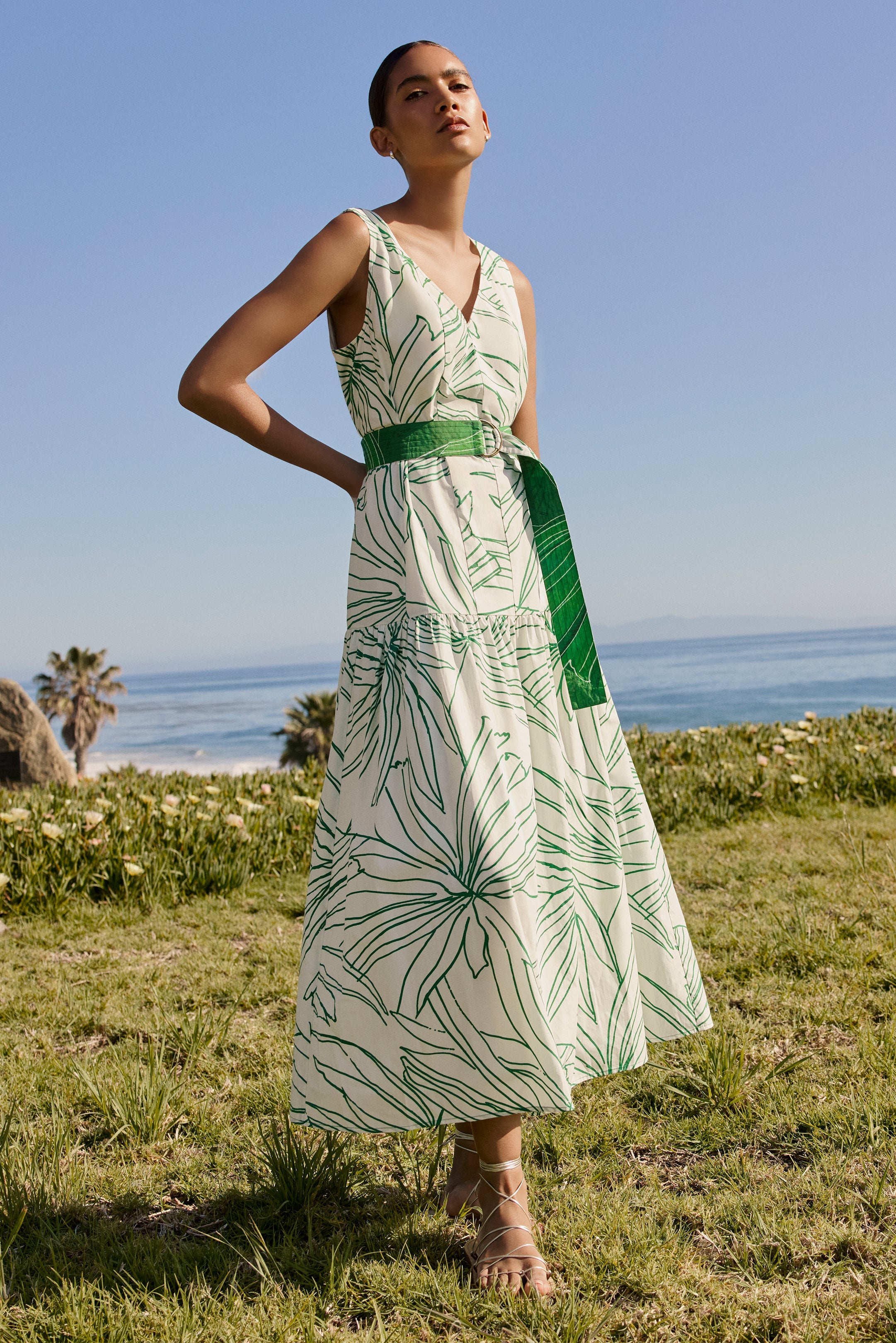 Sleeveless midi dress with green tropical leaf print and belted waist