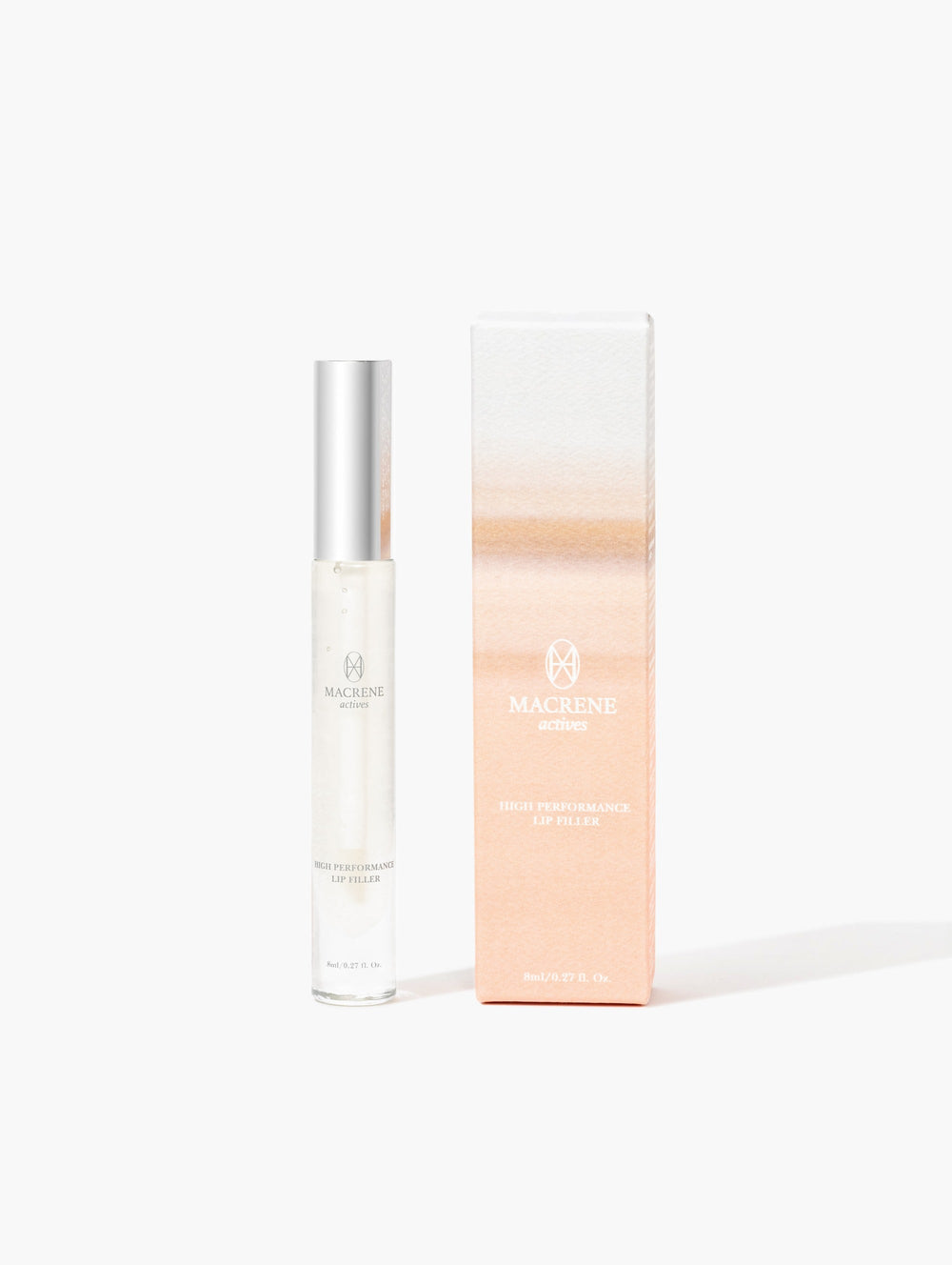 Front view of Macrene Actives High Performance Lip Filler with clear gloss in silver-capped tube beside peach-gradient box