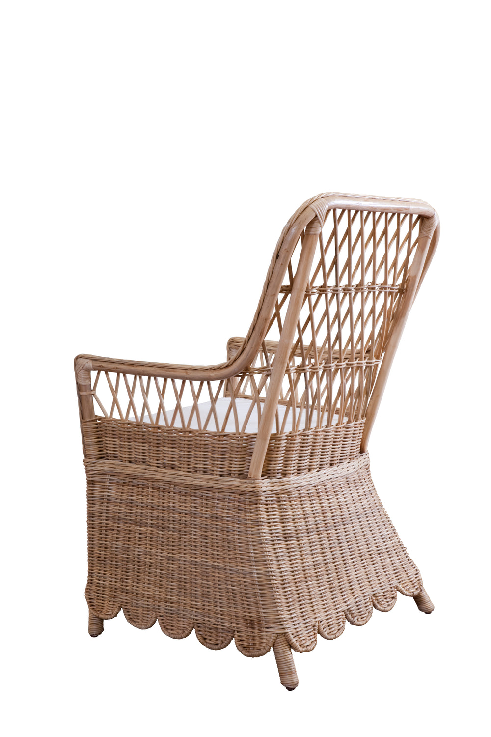 Rear three-quarter view of Monaco chair showcasing natural woven rattan frame, scalloped skirt, and white seat cushion on white background