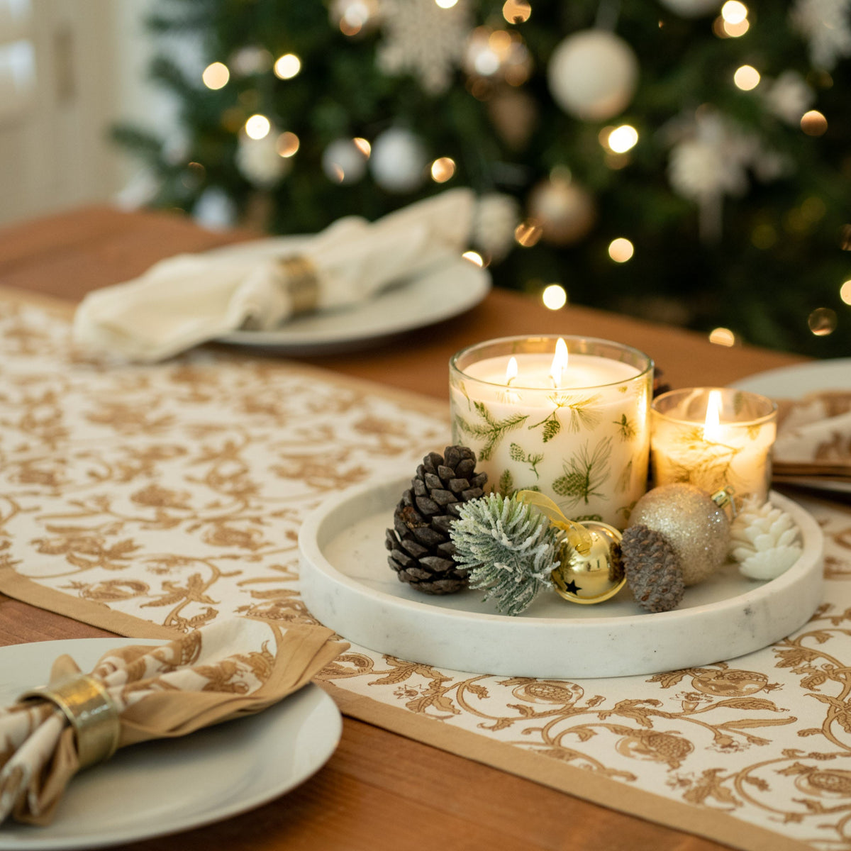Granada Runner in mustard decorates a table with plates, candles, and a festive centerpiece