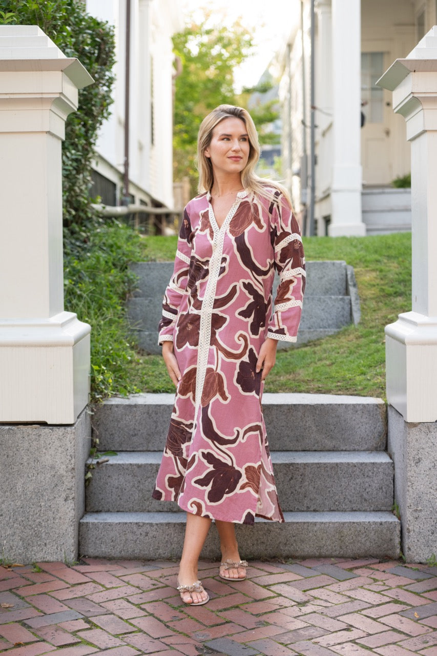 Front view of Bardot Merrain dress in pink showing V-neck, cotton lace trim and brown floral print on a model standing on outdoor steps