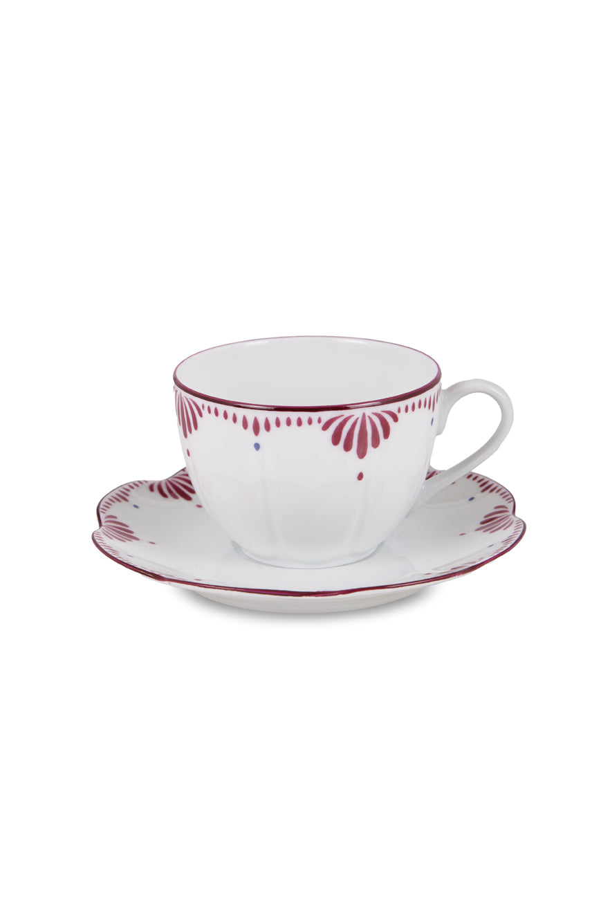 Front view of Jaipur tea cup with plate showcasing scalloped rim and hand painted pink and blue pattern on white background
