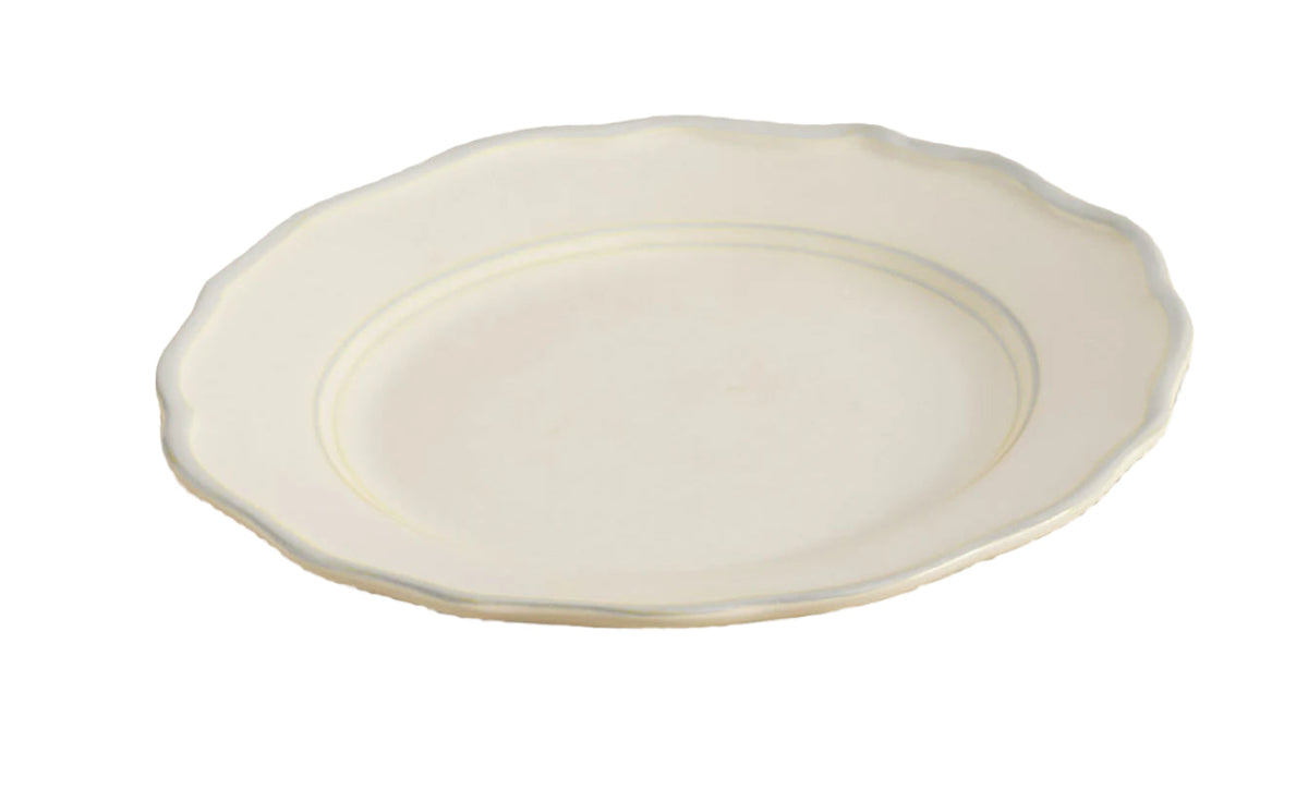Angled view of Sylvia Dinner Plate, Set of 4 showcasing scalloped edge and soft brushstroke finish on a white background