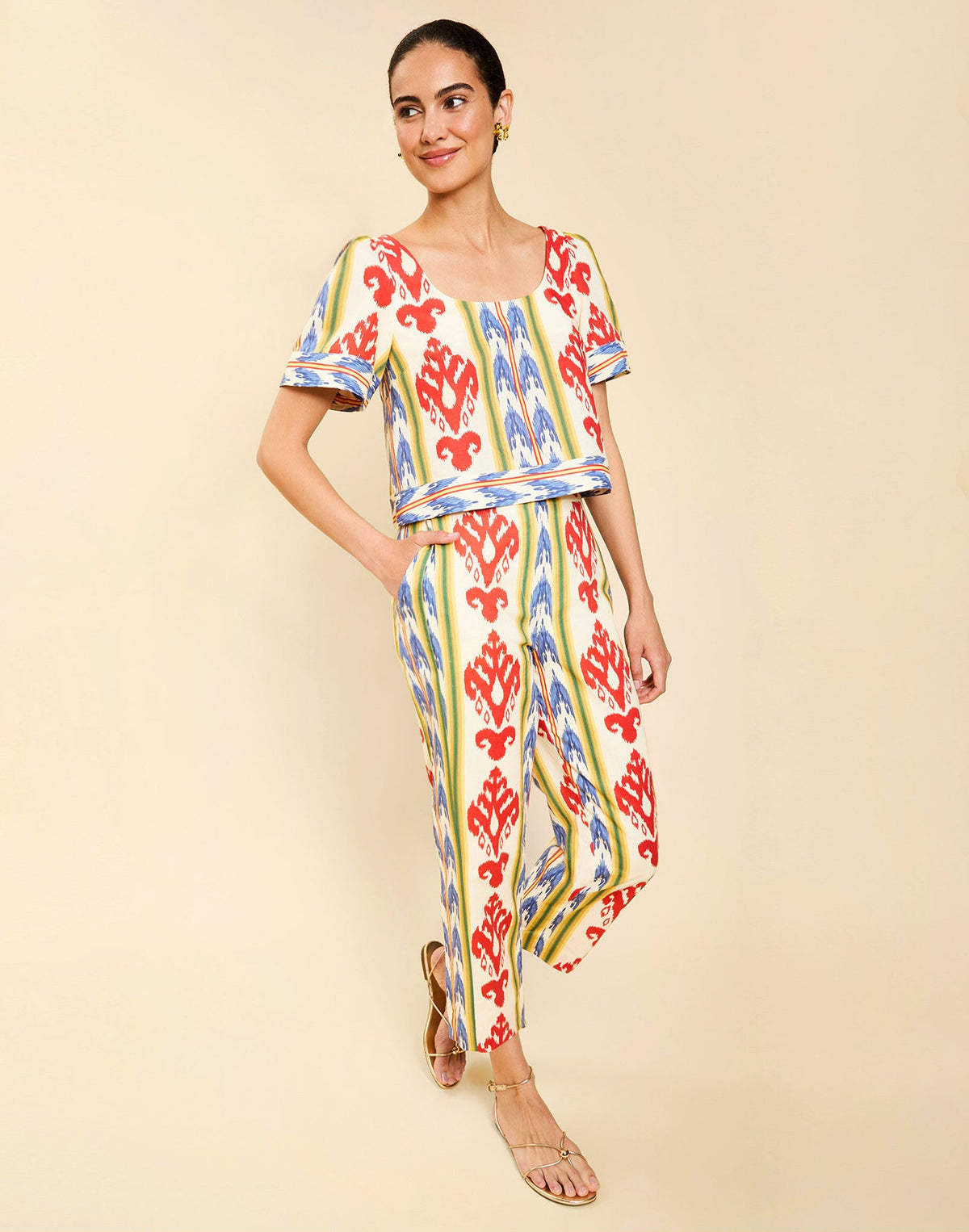 Woman wearing the Mestiza Maldives Top in Ikat Sunrise print, featuring a boxy silhouette, deep scoop neckline, pleated flutter sleeves, contrast ivory trim, and lightweight linen fabrication.