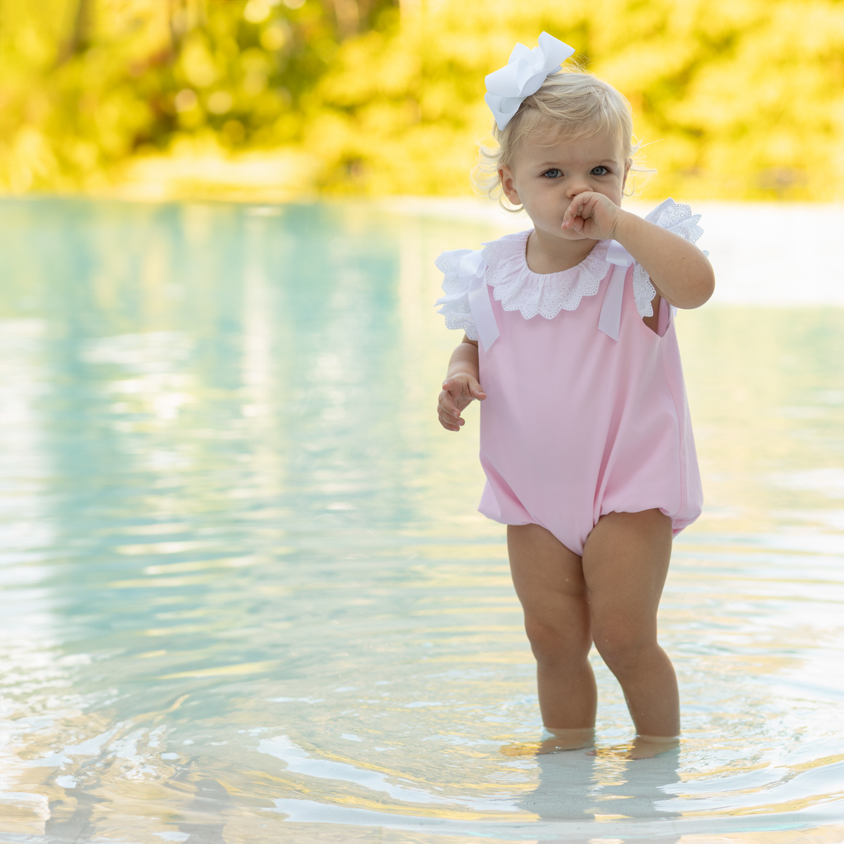 Toddler girl wearing the Henry Duvall Rosie Bubble, a classic pink bubble designed for spring days and special moments.