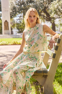 The Alexis Skirt in Garden Rose Peony paired with matching Manning Top sitting on bench in sun.