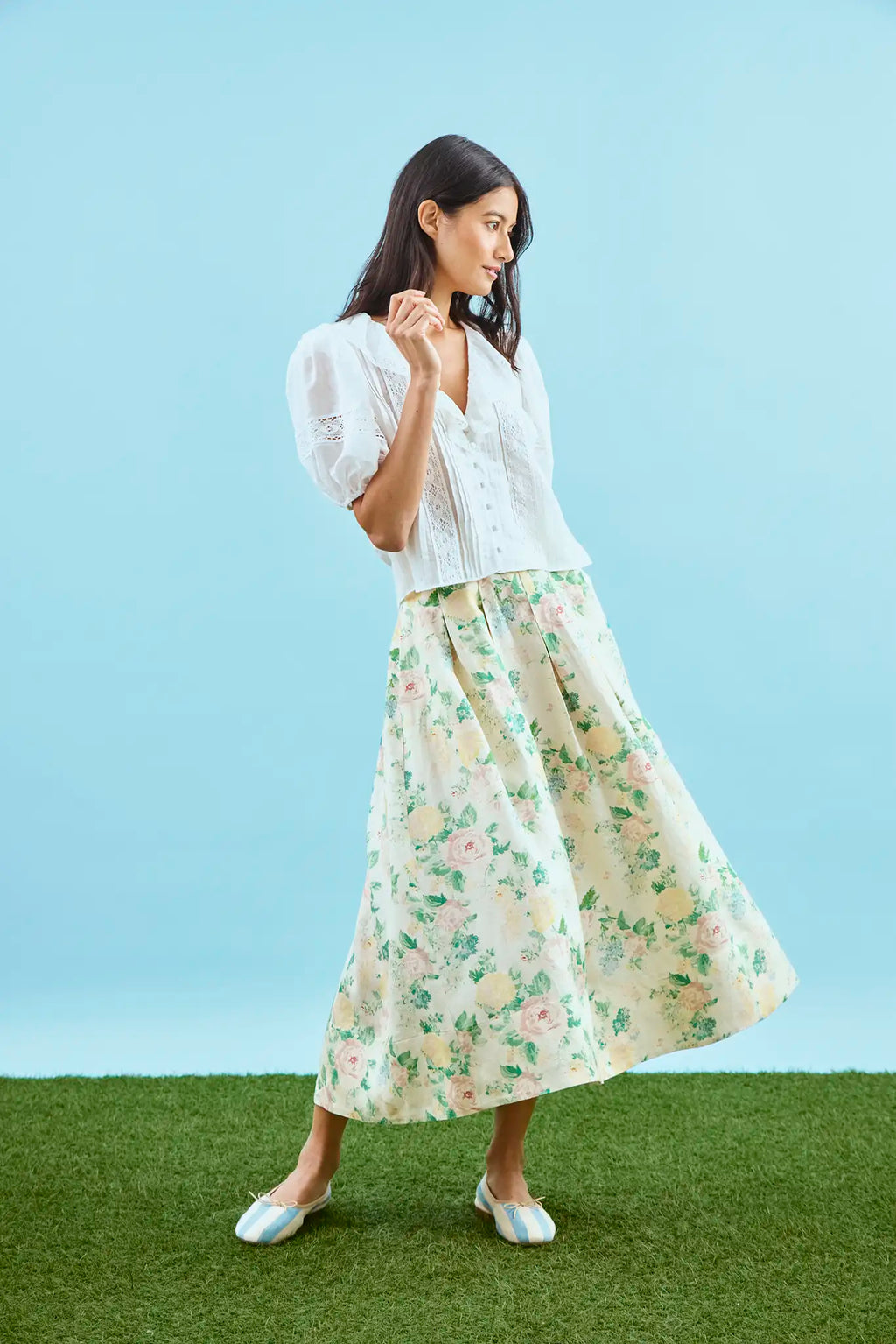 The Alexis Skirt in Garden Rose Peony paired with white Mare Top with blue background.