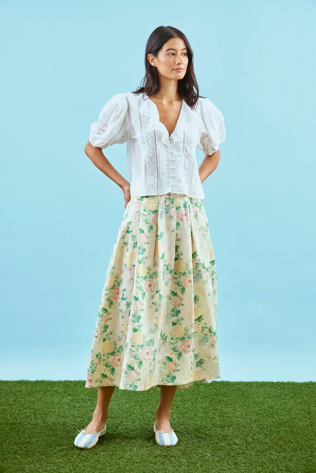The Alexis Skirt in Garden Rose Peony paired with white Mare Top with blue background.