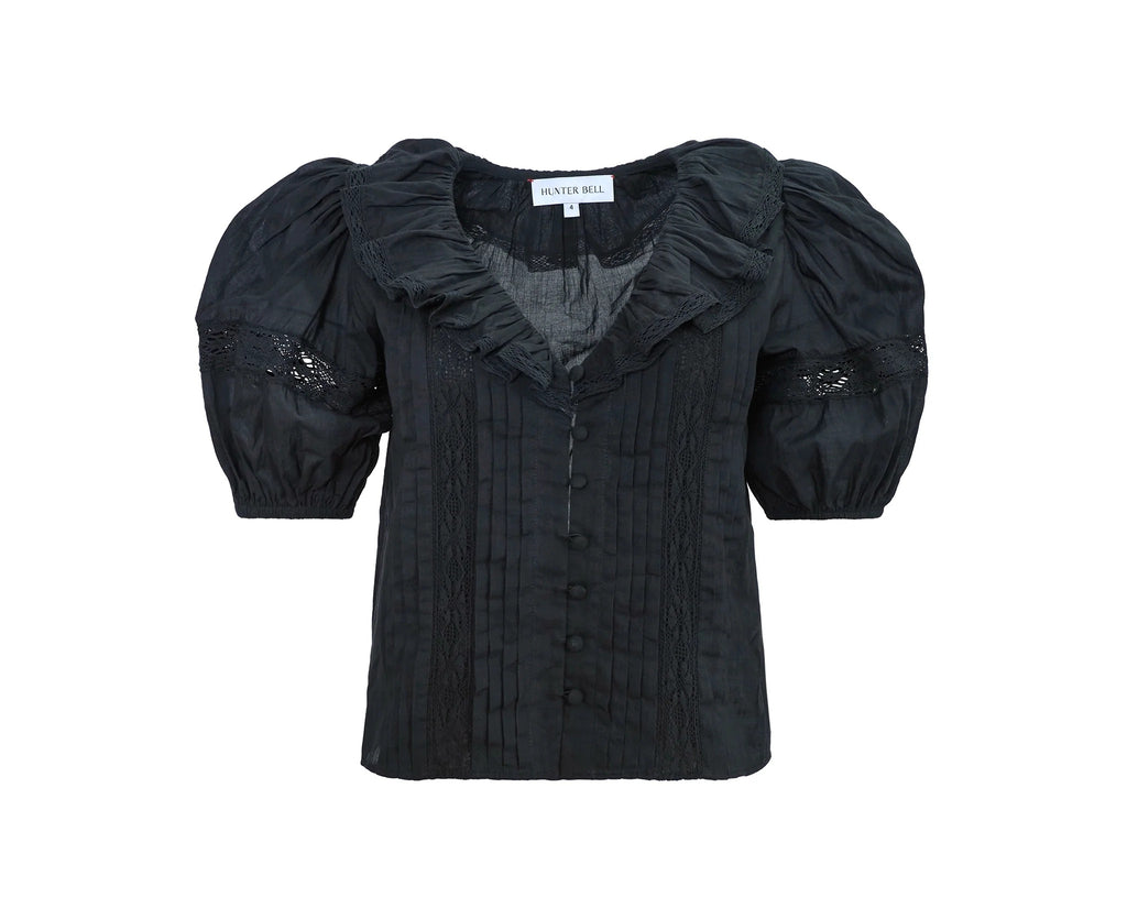 Front view of Mare Top in Onyx showcasing ruffled V-neckline, pintuck bodice, lace insets, and button closure with white background