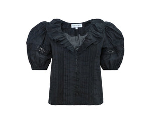 Front view of Mare Top in Onyx showcasing ruffled V-neckline, pintuck bodice, lace insets, and button closure with white background