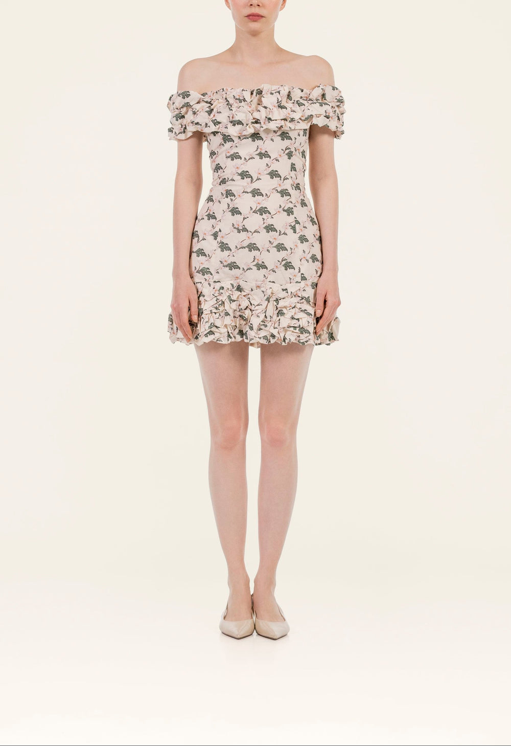 Front view of Jardin Anhelo mini dress on model showcasing off-shoulder ruffled neckline, fitted floral print and ruffle hem
