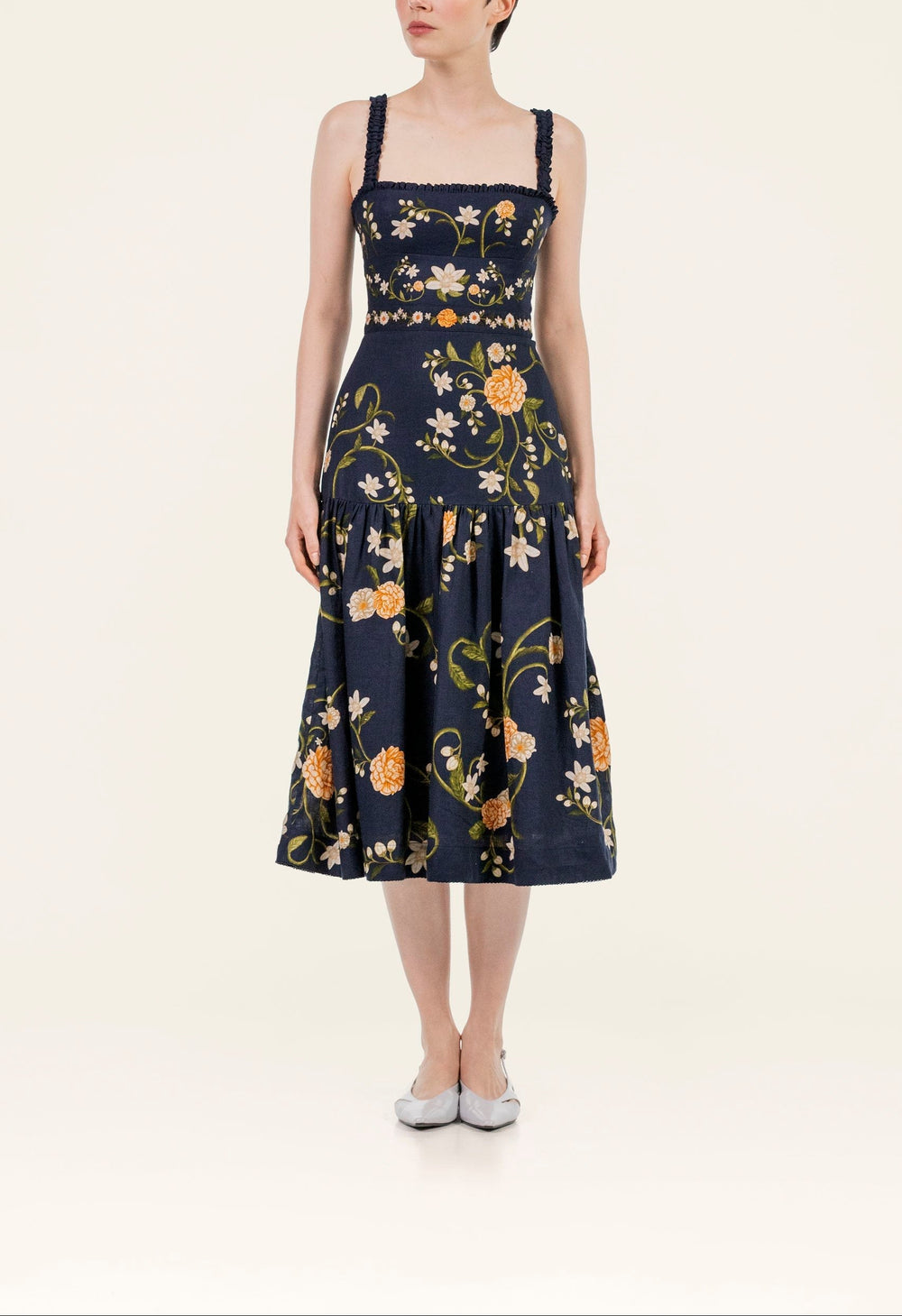 Front view of Nispero Valle midi dress showcasing square neckline, smocked straps, fitted waist and orange floral print