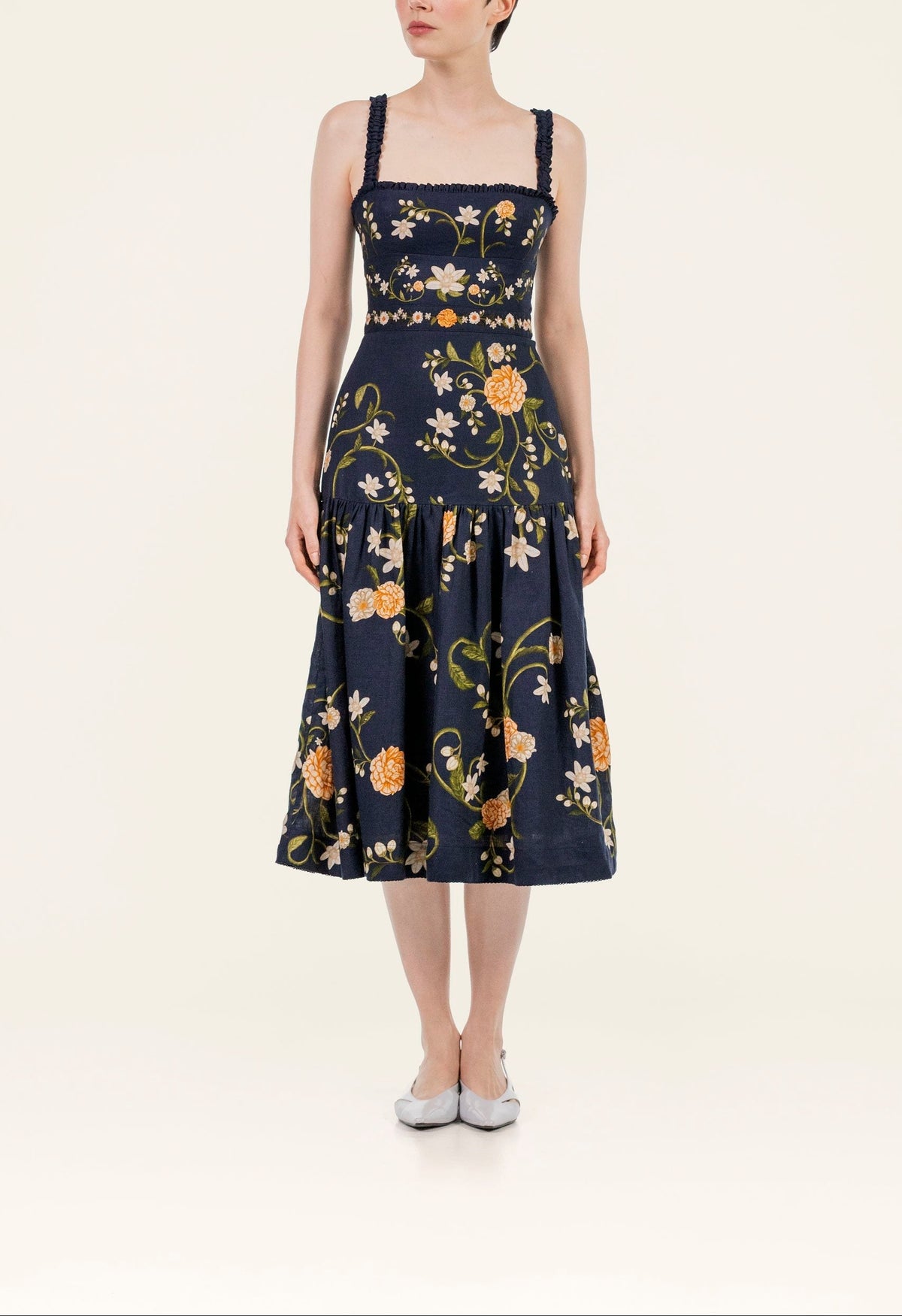 Front view of Nispero Valle midi dress showcasing square neckline, smocked straps, fitted waist and orange floral print