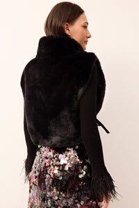 Sleeveless black furry vest featuring a turtleneck and adjustable tie sides